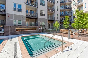 A small pool in a courtyard surrounded by buildings.